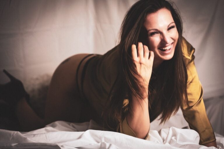 beautiful long haired brunette laughing during her boudoir session at Las Vegas Studio Shamelessly Sexy